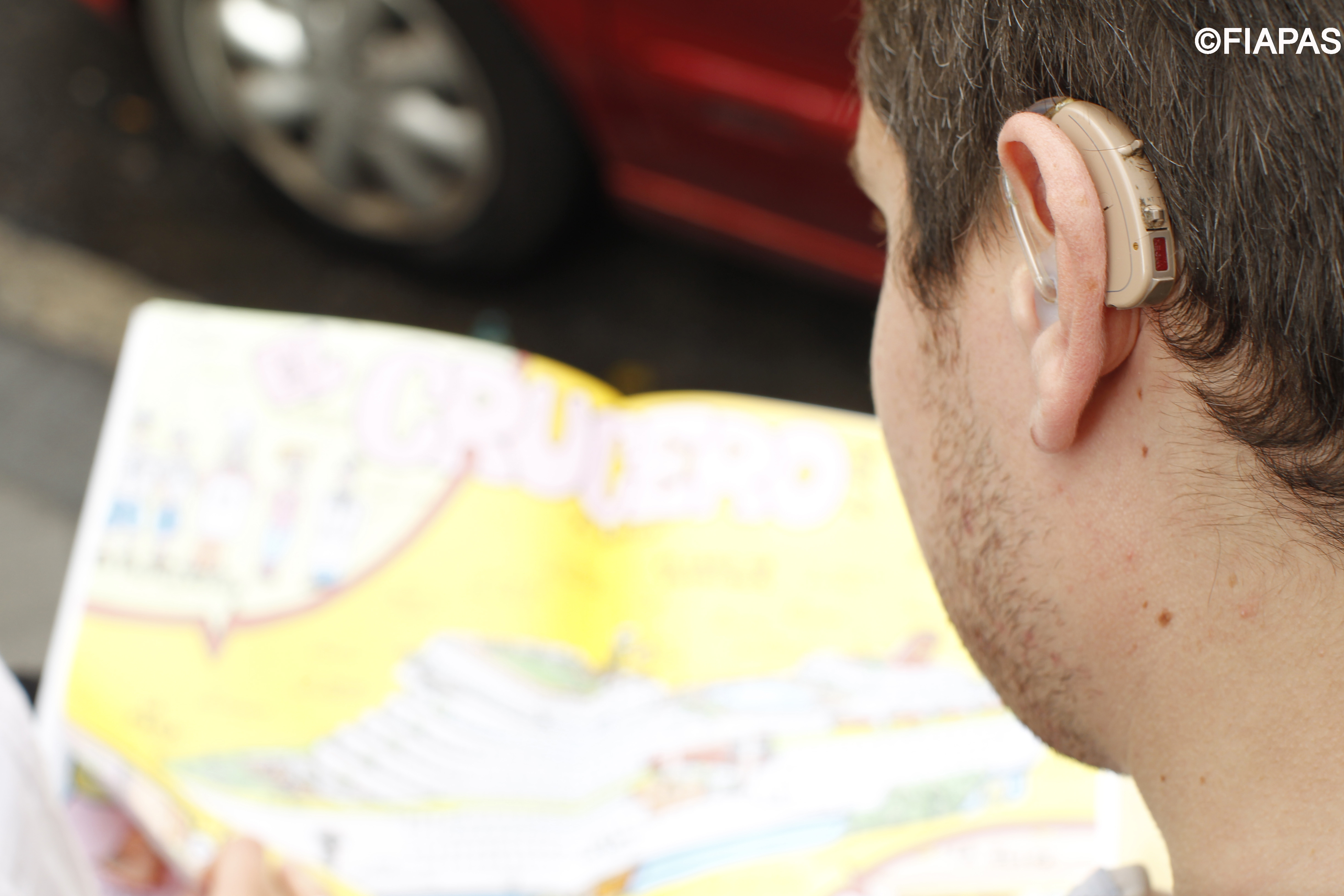 Imagen de un joven portando un audífono en su oreja izquierda