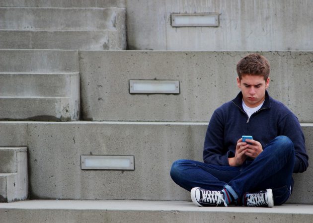 texting_boy_teenager_sitting_outdoor_blue-1198474